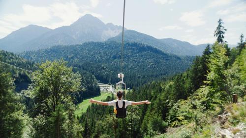 a person on a zip line in the mountains at Ferienwohnung Wolfsberg in Reutte