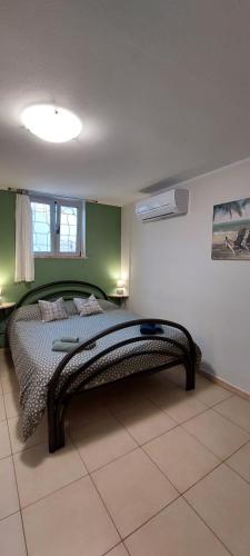 a bedroom with a bed in a room with green walls at Appartamento Limone in Cala Gonone