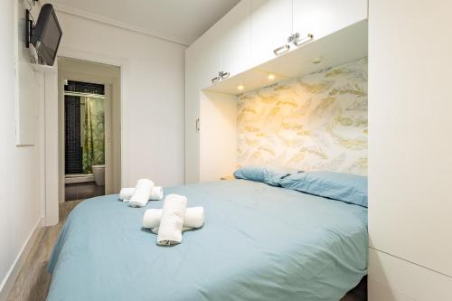 ein Schlafzimmer mit einem großen blauen Bett mit Handtüchern darauf in der Unterkunft Súpercéntrico Santander in Santander