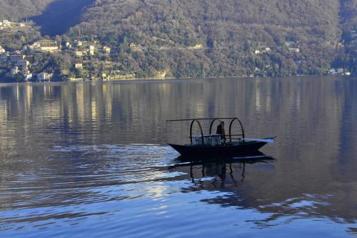 a boat in the middle of a large body of water at Appartamento Country House Menaggio in Menaggio
