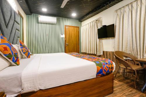 a bedroom with a bed and a television and a table at FabExpress Malali Residency in Mumbai