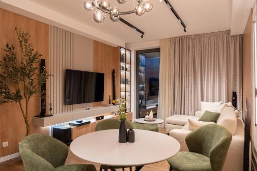 a living room with a couch and a table and chairs at Planet Residence NiNa in Niš