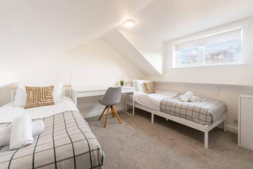a bedroom with two beds and a desk and a window at Westfield Town-House Free Parking, Secure Garden in Caversham