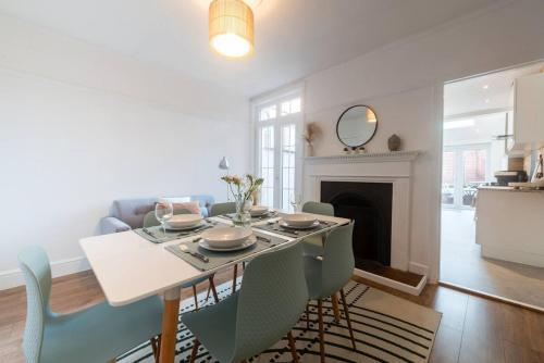 a dining room with a table and chairs and a fireplace at Westfield Town-House Free Parking, Secure Garden in Caversham