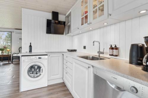 a white kitchen with a washing machine and a sink at The Wonderful Hornsherred And Isefjord in Skibby