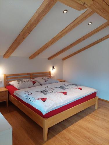 a bedroom with a large bed with red roses on it at Appartements - Haus Sieberer in Brixen im Thale