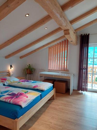 a bedroom with two beds and a desk at Appartements - Haus Sieberer in Brixen im Thale