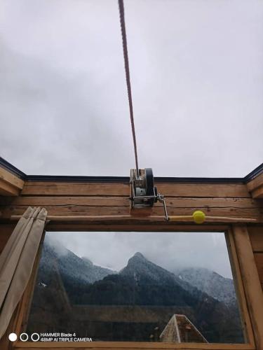 a view of a mountain through a window with a camera at Mazot étoilé toit ouvrant in La Balme-de-Thuy