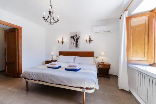 a bedroom with a bed with two towels on it at Villa para 10 personas con BBQ, piscina y terraza in S'Horta