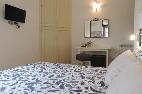 a bedroom with a bed and a desk and a mirror at Agriturismo Il Cavallino Saturnia in Semproniano