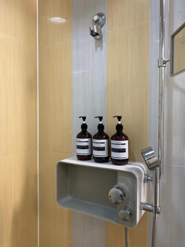 two bottles of shampoo sitting on a shelf in a shower at 분위기 좋은 초고층 제니하우스 in Seoul