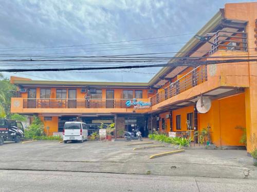 an orange building with a car parked in a parking lot at Sonly Hotel in General Santos