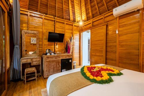 a bedroom with a bed with a flower arrangement on it at Angseri Villas in Tabanan