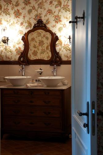 a bathroom with two sinks and a wooden dresser at Liepupe Manor in Liepupe