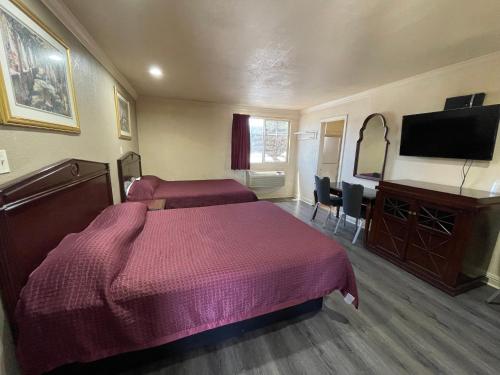 a bedroom with two beds and a flat screen tv at Seahorse Motel in Richmond