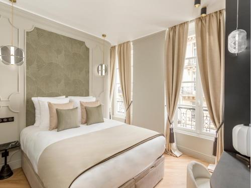 une chambre avec un grand lit blanc et une fenêtre dans l'établissement Merveil - Signature Suite - Marais - Montmartre, à Paris