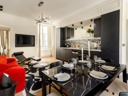 un salon avec un canapé rouge et une table dans l'établissement Merveil - Signature Suite - Marais - Montmartre, à Paris