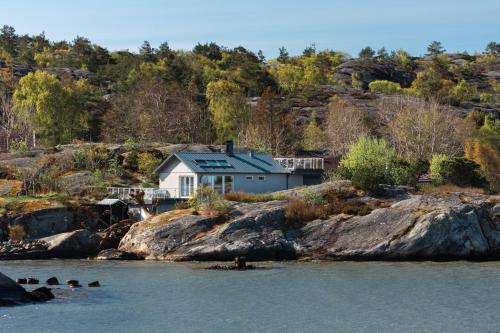 a house on the shore of a body of water at Sillvik C&J Hugosson in Sanden