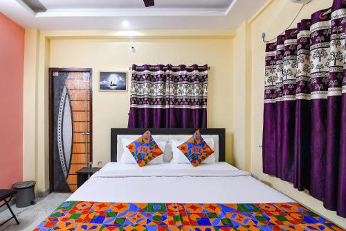 a bedroom with a bed with purple curtains at Comfort Stays Kolkata airport in Salua