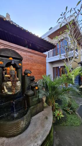 a fountain in the yard of a house at Asna House in Ubud