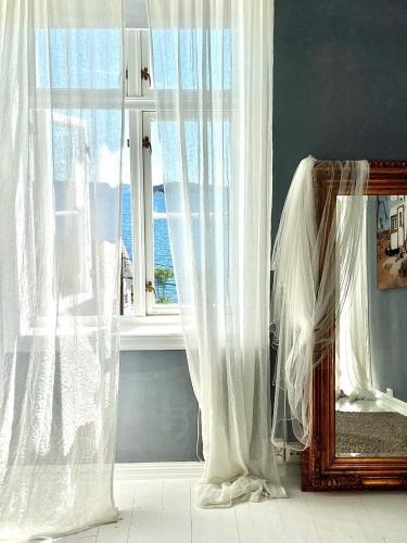 a mirror and curtains in a room with a window at Villa Utsikten in Tofte
