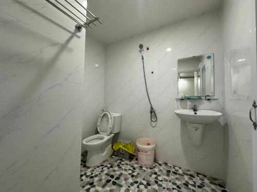 un bagno bianco con un water e un lavandino di Nhà Nghỉ Thuỳ Duyên a Ấp Long Sơn