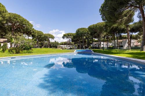 ein Swimmingpool mit blauem Wasser in einem Hof in der Unterkunft Waves & Pines Apartment El Paraiso, Benamara in Estepona