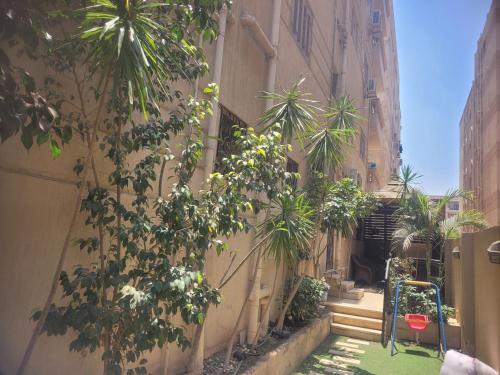 an alley with trees and plants on the side of a building at CozyHome 2BR Place New Cairo with Private Garden in Cairo