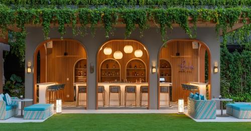 a restaurant with an outdoor bar with green vines at Meliá Pattaya Hotel in Pattaya Central