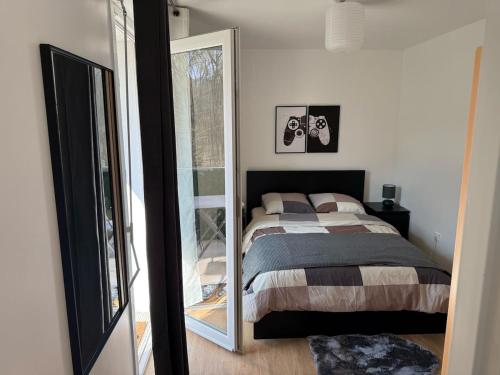 une chambre avec un lit et un miroir dans l'établissement Cosy apartment near Paris, à Montigny-lès-Cormeilles