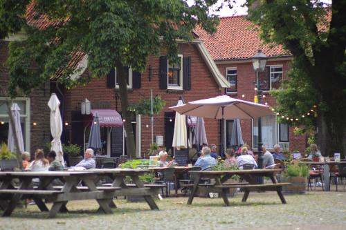 a group of people sitting at tables under an umbrella at Hotel Bertram in Bredevoort