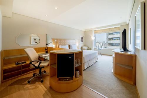 a hotel room with a bed and a desk and a tv at Hilton Sao Paulo Morumbi in Sao Paulo