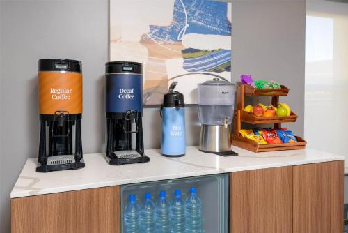 a kitchen counter with two coffee makers and bottles of water at Homewood Suites by Hilton Orlando-UCF Area in Orlando