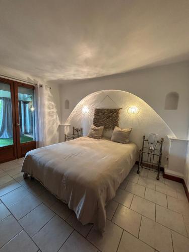 a bedroom with a large bed with an arched ceiling at L'écrin de Camargue in Saint-Gilles