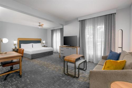 a hotel room with a bed and a couch at Homewood Suites by Hilton Orlando-UCF Area in Orlando