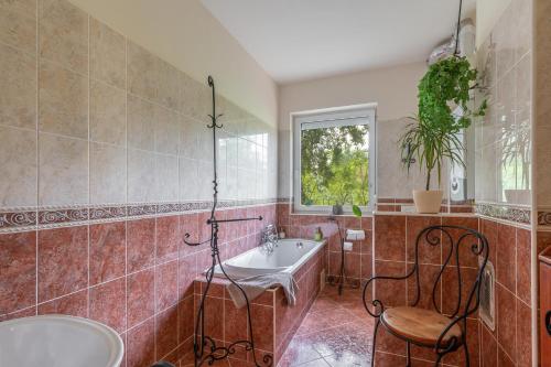 a bathroom with a tub and a sink and a chair at Király Családi Apartman- Royal Family Apartment #Freegarage in Budapest