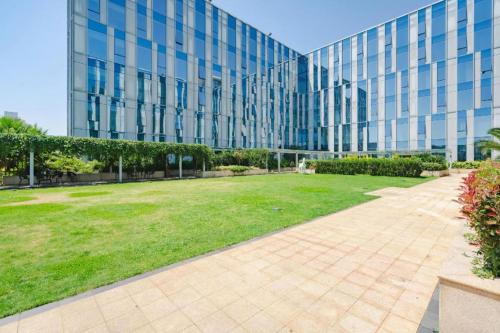 a large glass building with a lawn in front of it at Kunming Golden Eagle Summit Hotel in Kunming