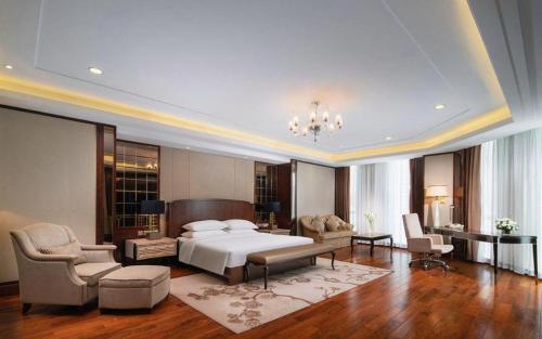 a bedroom with a bed and a living room at Kunming Golden Eagle Summit Hotel in Kunming