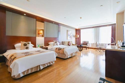 a hotel room with two beds and a desk at Kunming Golden Eagle Summit Hotel in Kunming