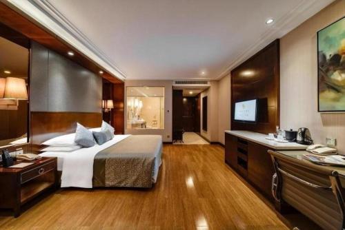 a hotel room with a bed and a flat screen tv at Kunming Golden Eagle Summit Hotel in Kunming