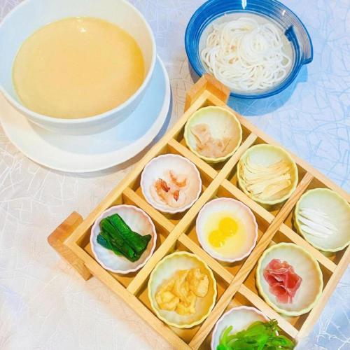 a tray of eggs and noodles and a bowl of soup at Kunming Golden Eagle Summit Hotel in Kunming