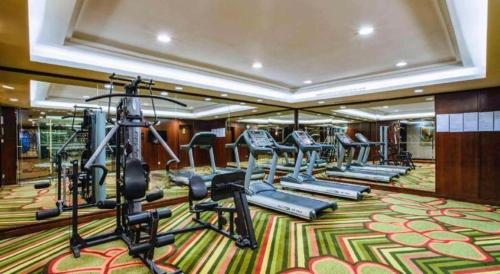 a gym with treadmills and ellipticals in a hotel room at Kunming Golden Eagle Summit Hotel in Kunming