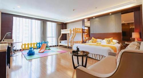 a large bedroom with a bed and a couch at Kunming Golden Eagle Summit Hotel in Kunming