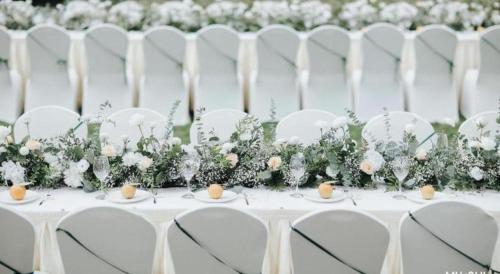 a table with white chairs and flowers on it at Kunming Golden Eagle Summit Hotel in Kunming