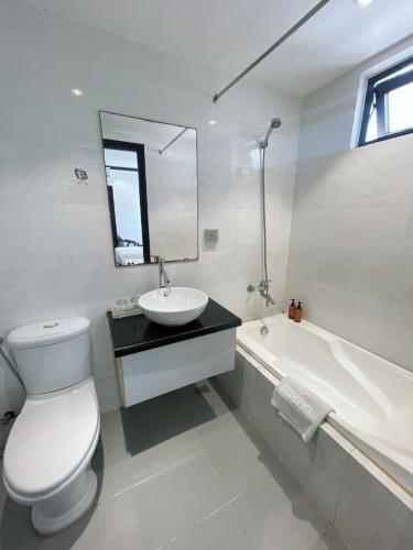 a bathroom with a toilet and a sink and a tub at RHM Asian Hotel Da Nang City in Da Nang