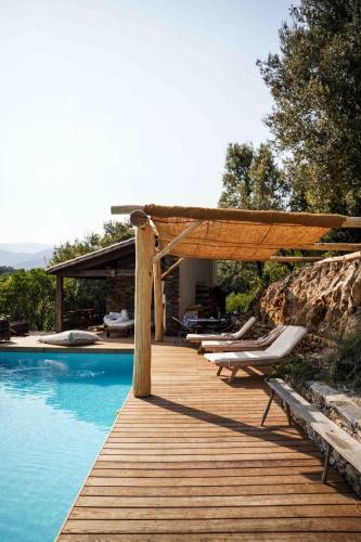 une terrasse en bois à côté d'une piscine avec des chaises dans l'établissement Le petit paradis cévenol - piscine & salle de sport, à Notre-Dame-de-la-Rouvière