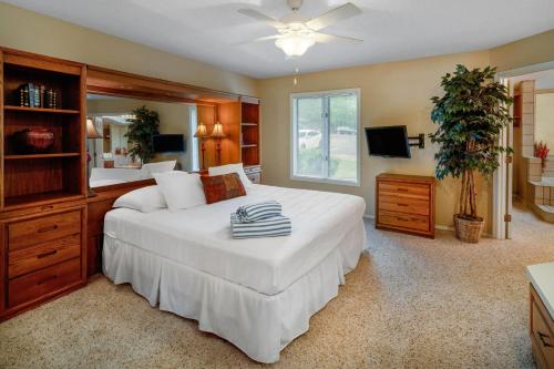 a bedroom with a large white bed and a television at Los Lagos at Hot Springs Village a Ramada by Wyndham in Hot Springs Village