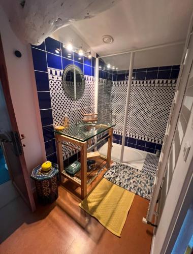 La salle de bains est pourvue d'une douche, d'une table et d'un miroir. dans l'établissement Le petit paradis cévenol - piscine & salle de sport, à Notre-Dame-de-la-Rouvière