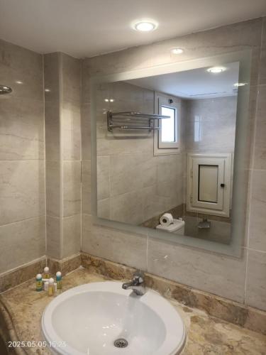 a bathroom with a sink and a large mirror at Salma Hotel Cairo in Cairo