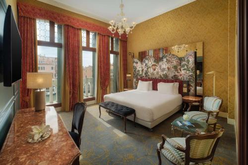 a hotel room with a bed and a table and chairs at NH Venezia Santa Lucia in Venice